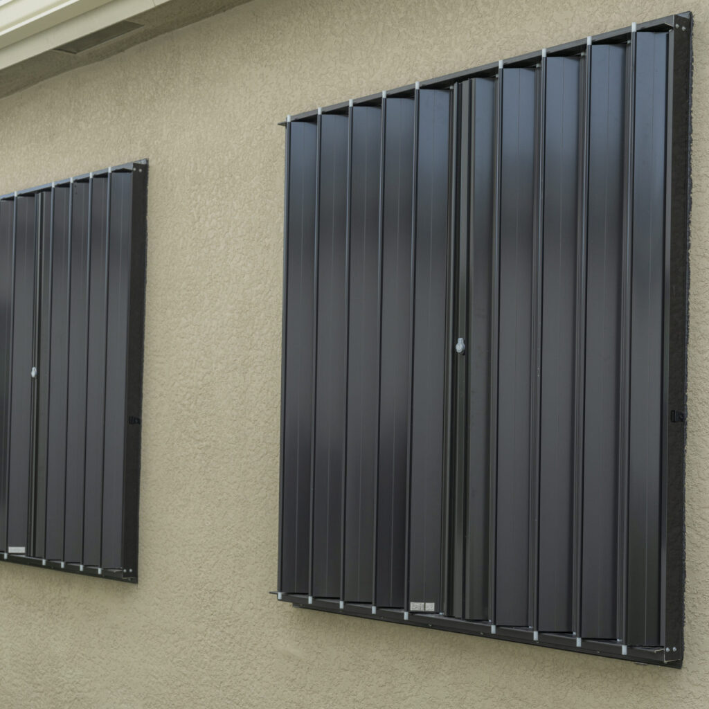 Black accordion shutters on a beige home