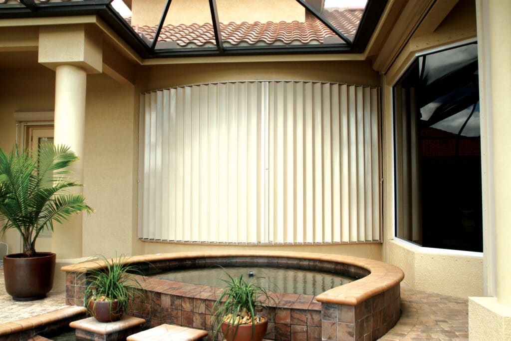 Hurricane protection shutter covering curved window in Florida.